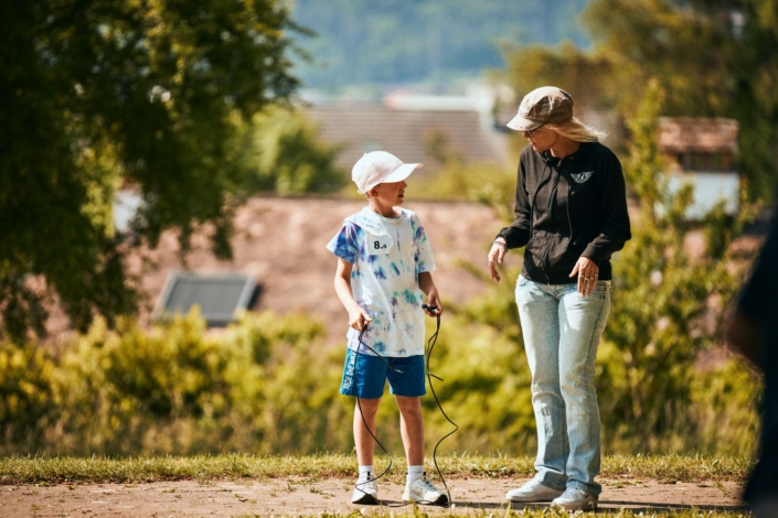 Lehrerin gibt einem Jungen Tipps zum Seilspringen