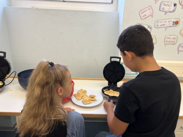 Zwei Kinder am Waffeln backen