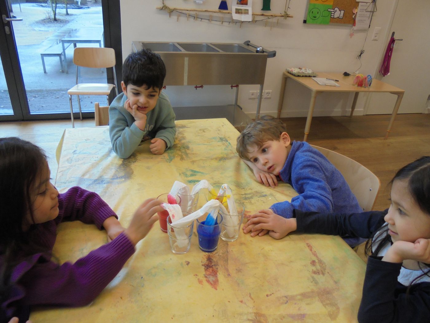 Kinder gucken gespannt, wie das Papier die Farben aufsaugt