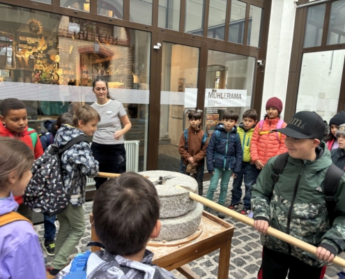 Kinder drehen am Mühlestein