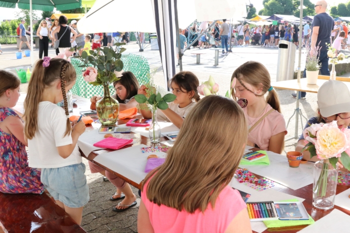 Kinder schmücken ihre Pflanzentöpfe