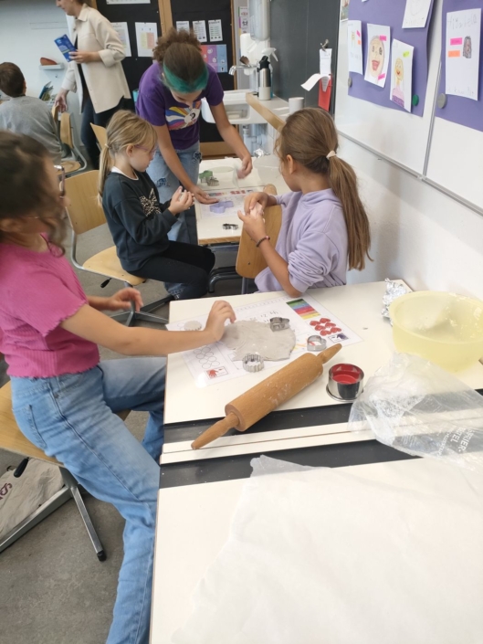 Blick ins Schulzimmer. Mehrere Kinder stechen Salzteigformen aus.