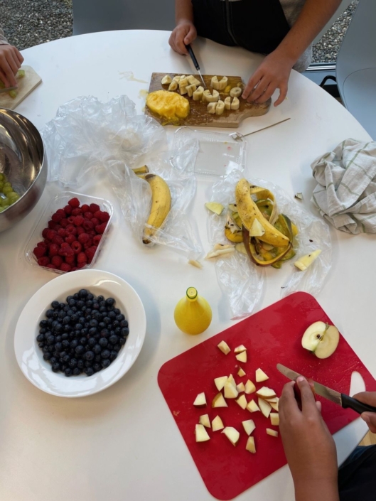 Kinder bereiten den Fruchtsalat vor