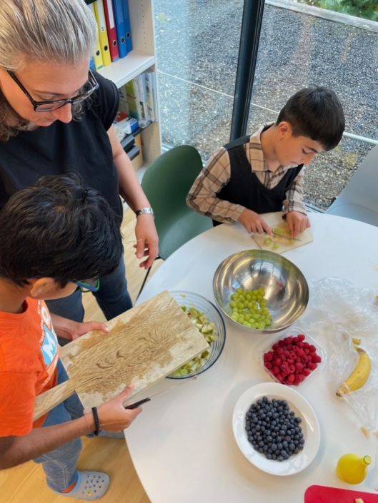 Kinder bereiten den Fruchtsalat vor