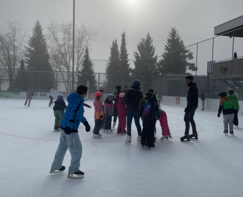 Eine Gruppe Kinder steht zusammen auf dem Eisfeld.