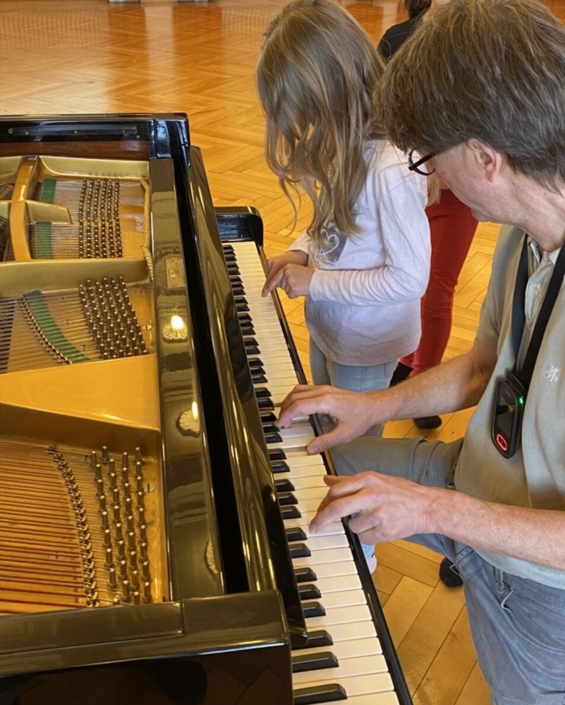 Kind spielt am offenen Flügel