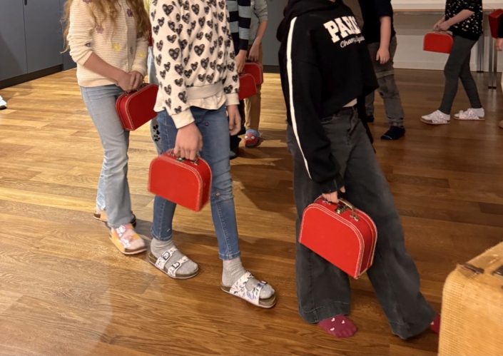 20260324_Werkgeschichte_UST_09 Kinder spazieren mit Koffer