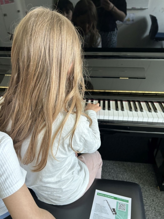 20260508_Instrumentenvorstellung_2Klasse_06 Mädchen spielt Klavier