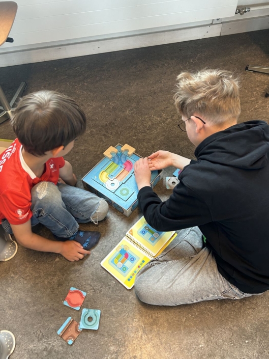 Zwei Jungen spielen ein Knobelspiel