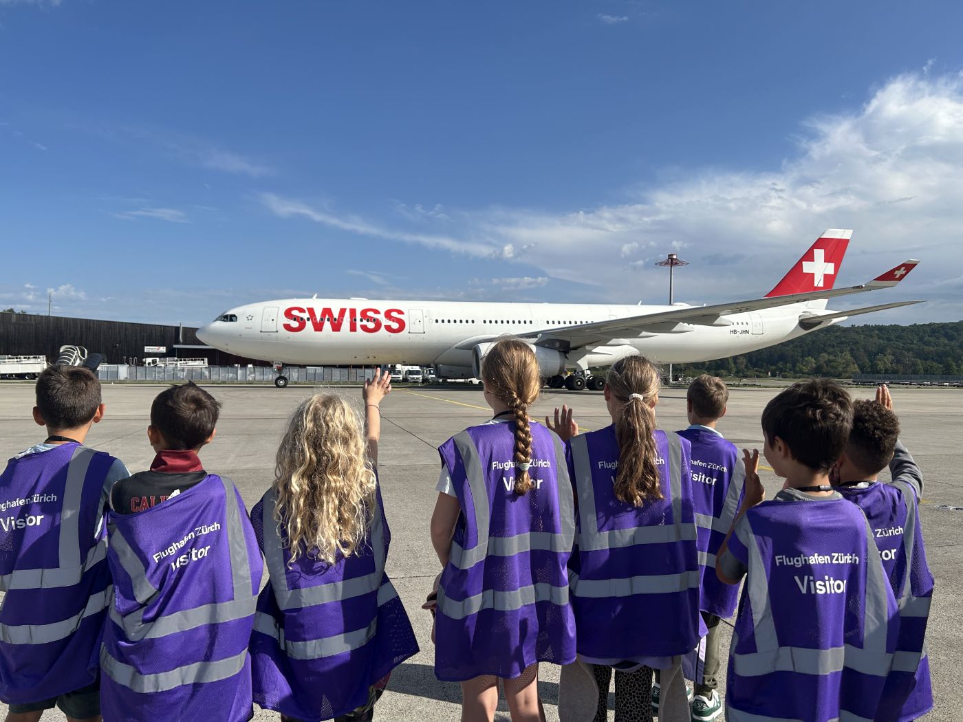 Kinder winken Swiss Flugzeug